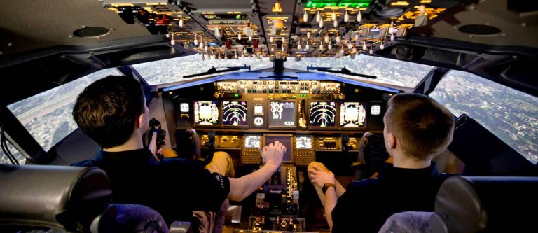 Two students at the controls of the FDS B737 NG flight training device at the University of Nebraska at Omaha Aviation Institute